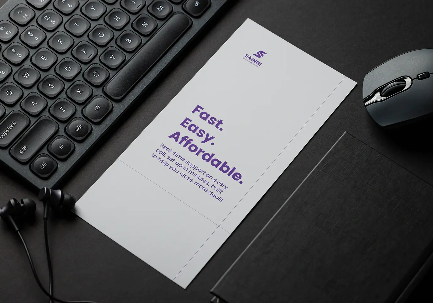 Sainni branded flyer on a dark desk next to a keyboard, mouse and earphones, displaying the words Fast, Easy, Affordable in bold purple typography